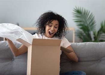 woman excitedly opening a package