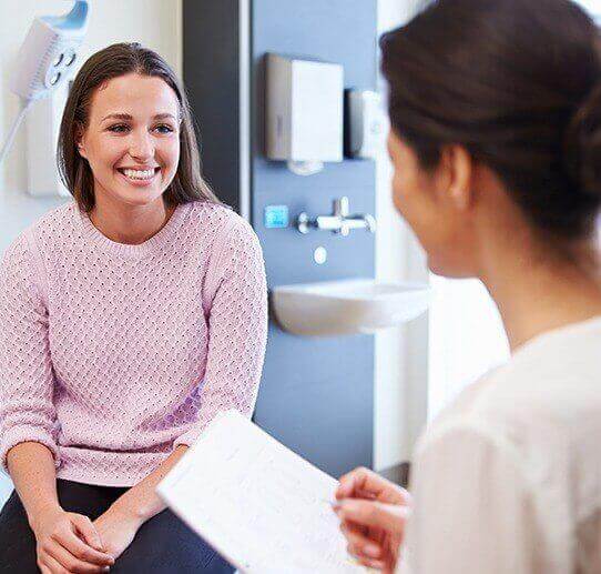 Young woman wearing pink sweater in dental office