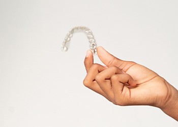 Closeup of teen holding clear aligner