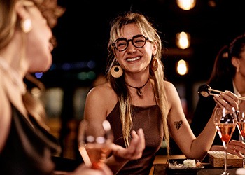 Friends smiling while enjoying meal together