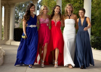 Group of teen girls smiling in prom dresses