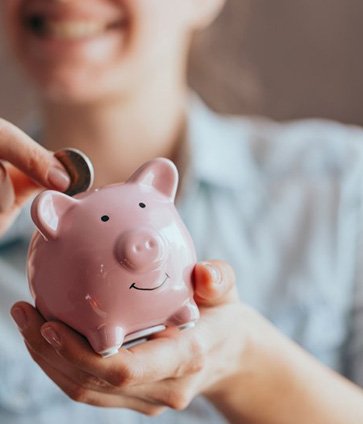 Woman inserting a coin into her piggy bank