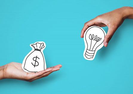 One hand holding a money bag graphic while the other holds a lightbulb graphic