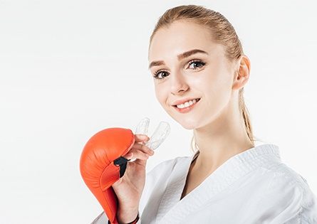 Woman placing athletic mouthguard