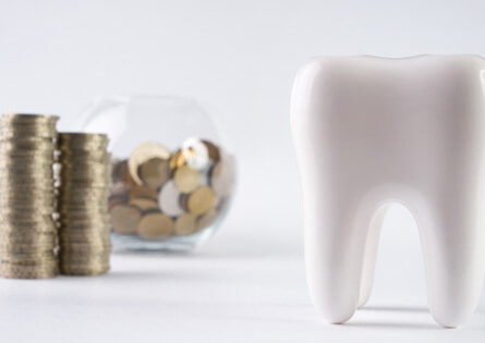 tooth next to a bowl of coins