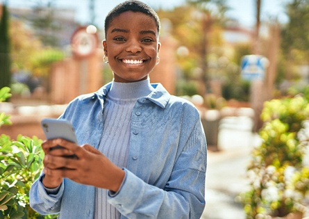 a smiling person with their phone in their hands