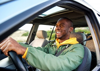 Man smiles in car