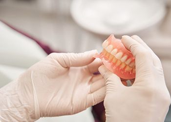 a technician holding a pair of dentures