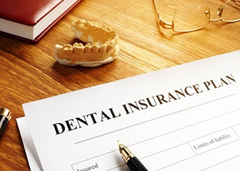 a dental insurance form next to wax dentures