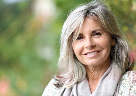 Woman with scarf smiling with dentures in North Dallas