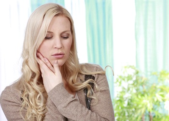 Woman with hands on her face in pain