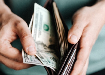 Man holding open wallet with cash