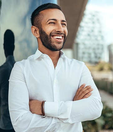 Young man smiling after receiving tooth-colored fillings in Dallas