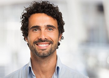 Man in collared shirt smiling with dental implants in North Dallas