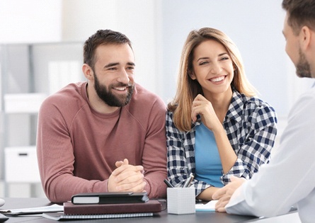 A couple speaking with the dentist about implant supported denture placement