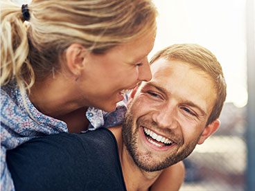 Smiling man and woman outdoors