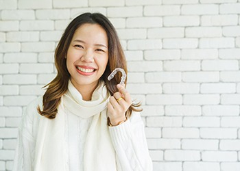 Woman holding Invisalign aligner