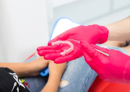 Dentist showing patient Invisalign tray