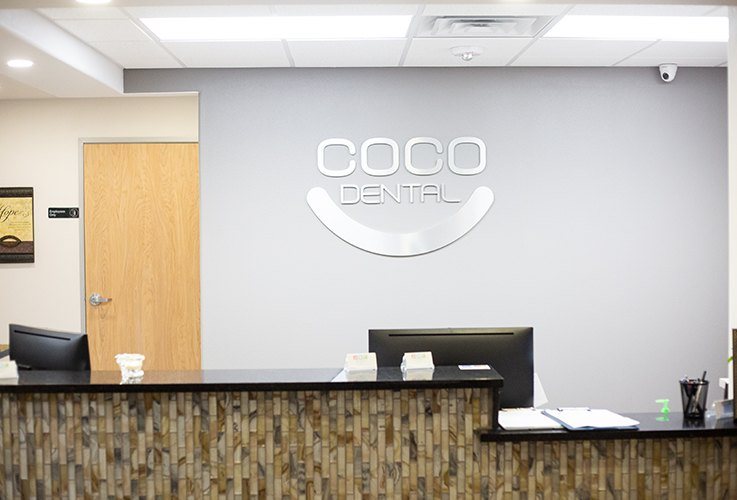Coco Dental sign above dental reception desk