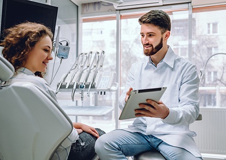 Dentist showing dental patient a tablet