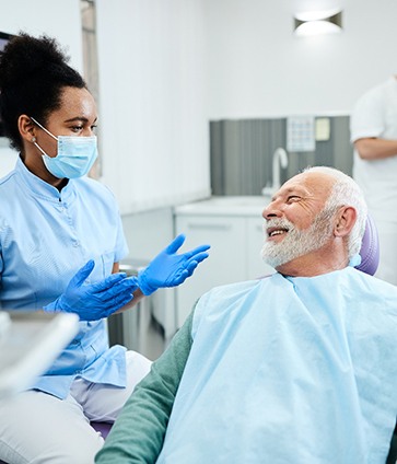 A dentist talking to her patient about dental implant failure and salvage