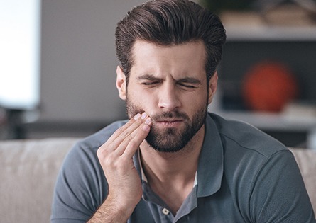 A young man suffering the symptoms of dental implant failure