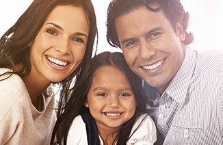 Mother father and child with healthy smiles thanks to preventive dentistry