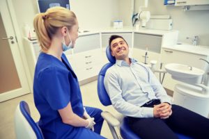 man in blue dress shirt smiling in dental chair