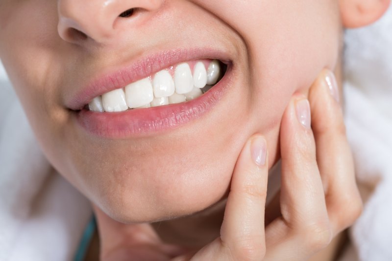 Person holding their tooth in pain