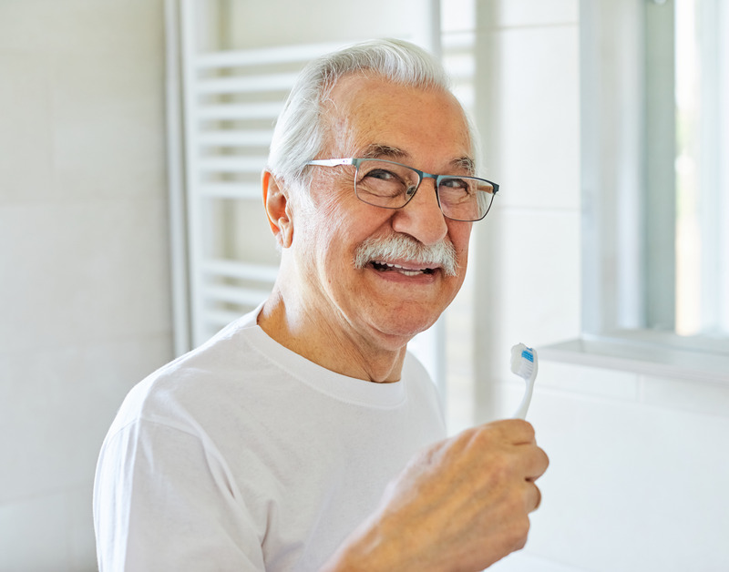 Patient brushing their dentures