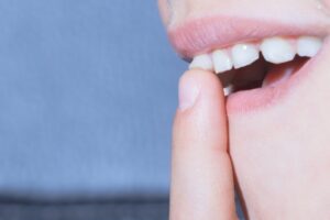 Person touching loose front tooth.